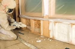 Technician installing spray foam in wall